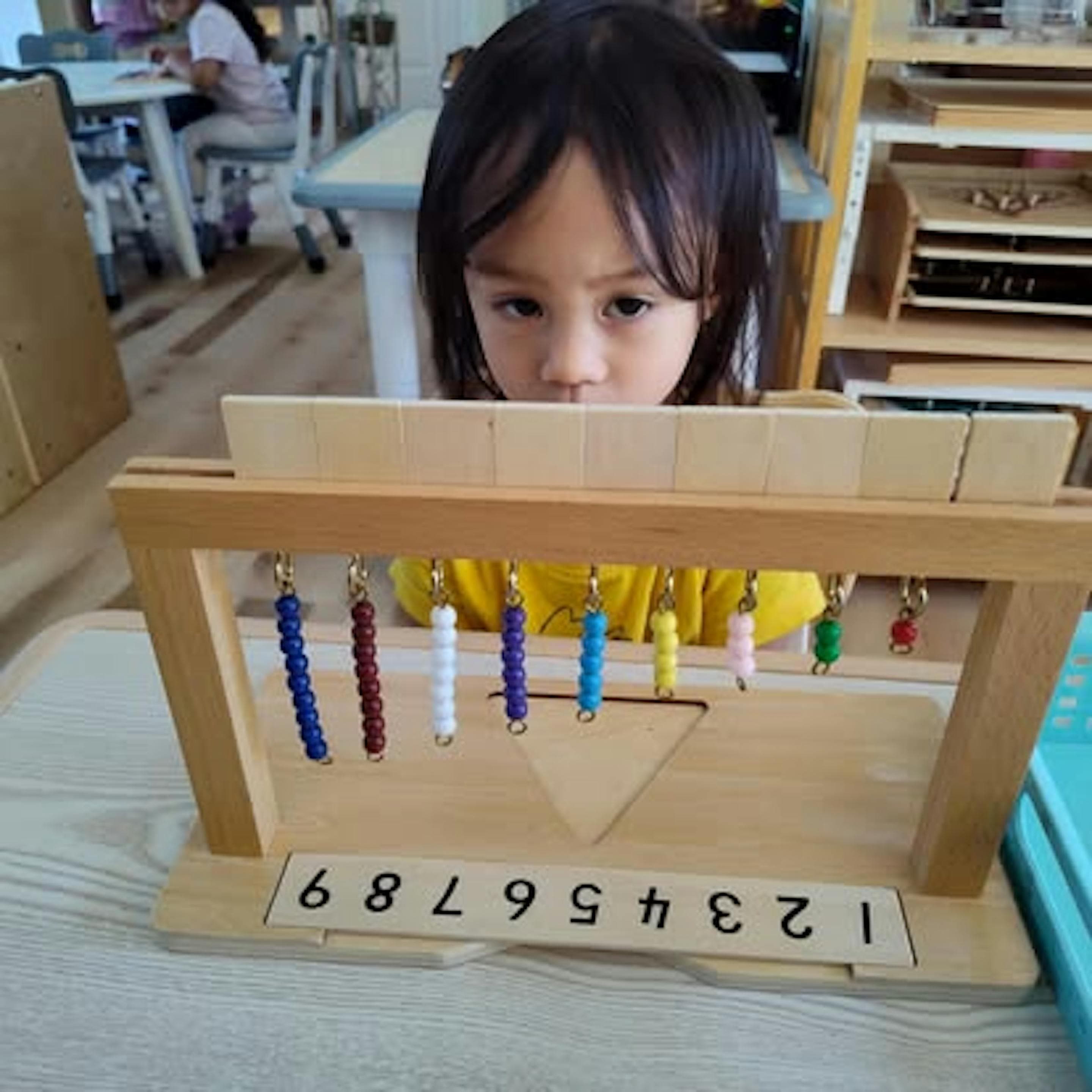 Child contemplating the Montessori bead stair